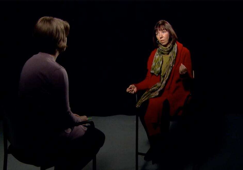Two women talking as they sit facing each other on a studio set.
