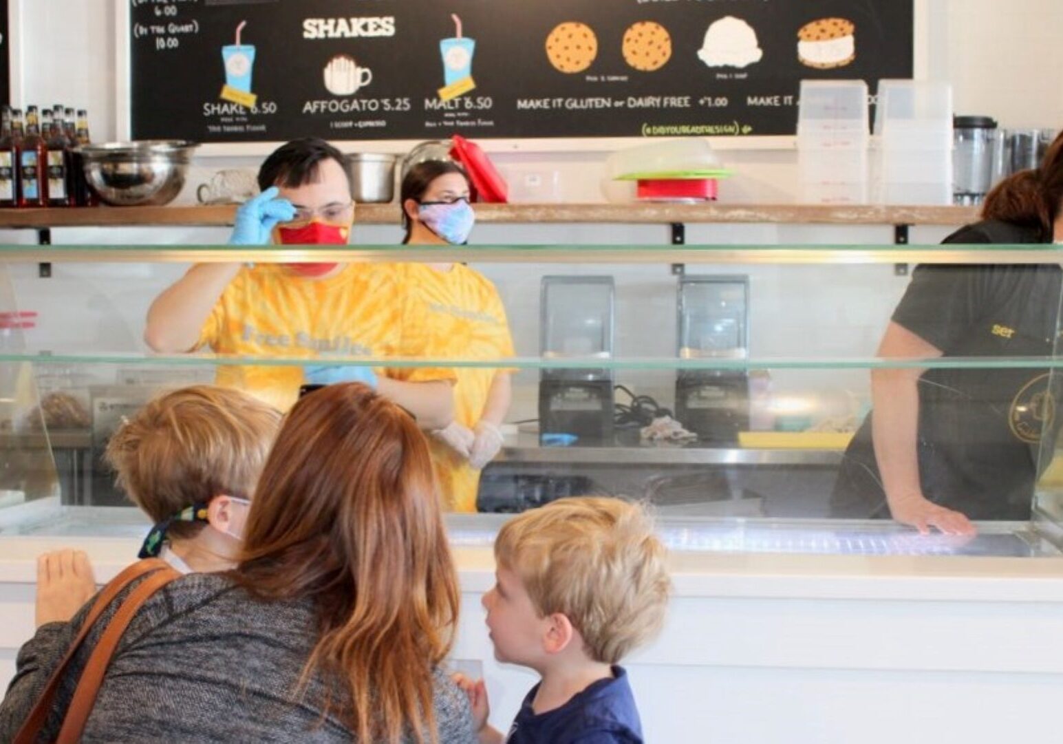 Brett Hughes waits on customers while Rachel Seaman makes ice cream and Michelle Reeves (right) serves as a coach at The Golden Scoop.