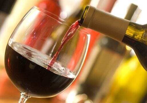 A glass of red wine being poured.