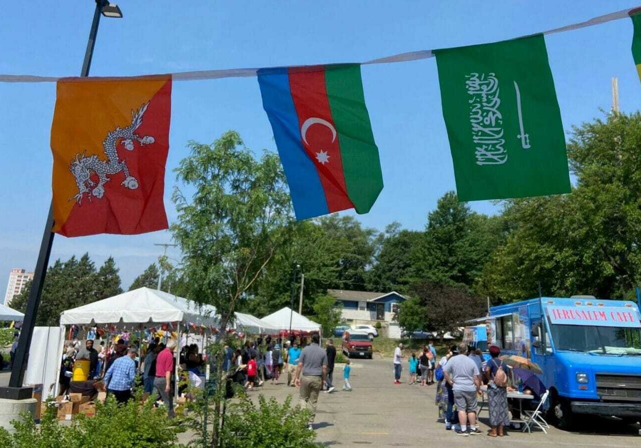 People, businesses and service organizations gather in a parking lot for Kansas City's World Refugee Day event.