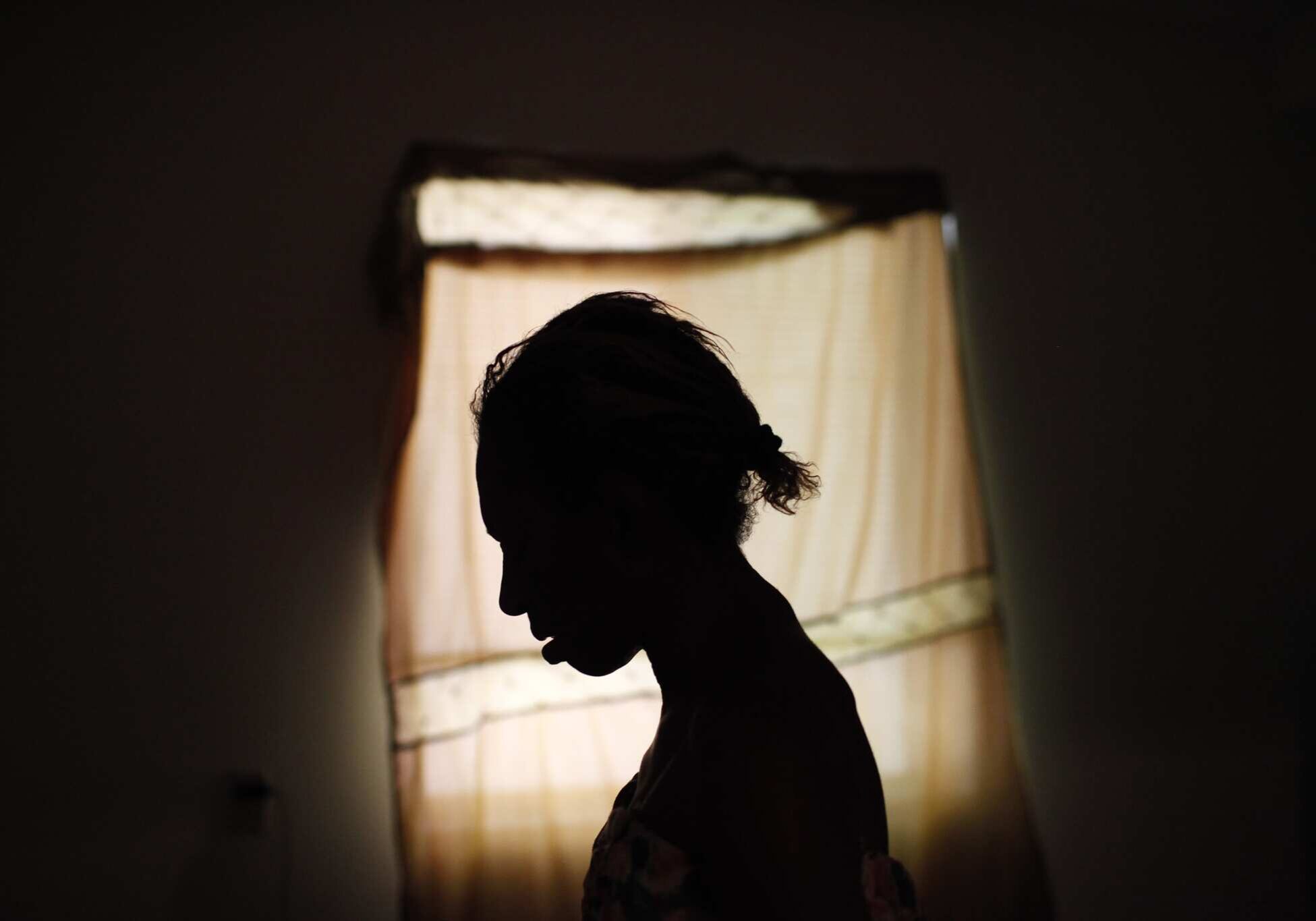 Sheila Nichols, 55, is silhouetted as she stands in room at the Charles Cobb Apartments in Los Angeles, Monday, July 19, 2010. After two decades living on the streets of Skid Row, Nichols was dying. Her body had wasted away to 61 pounds, ravaged by a heavy-duty crack cocaine addiction, hepatitis, HIV, and late-stage syphilis. Nichols was rescued by Project 50, a pilot program to get the 50 people most likely to die if they remained homeless into housing, medical care and social services. (AP Photo/Jae C. Hong)