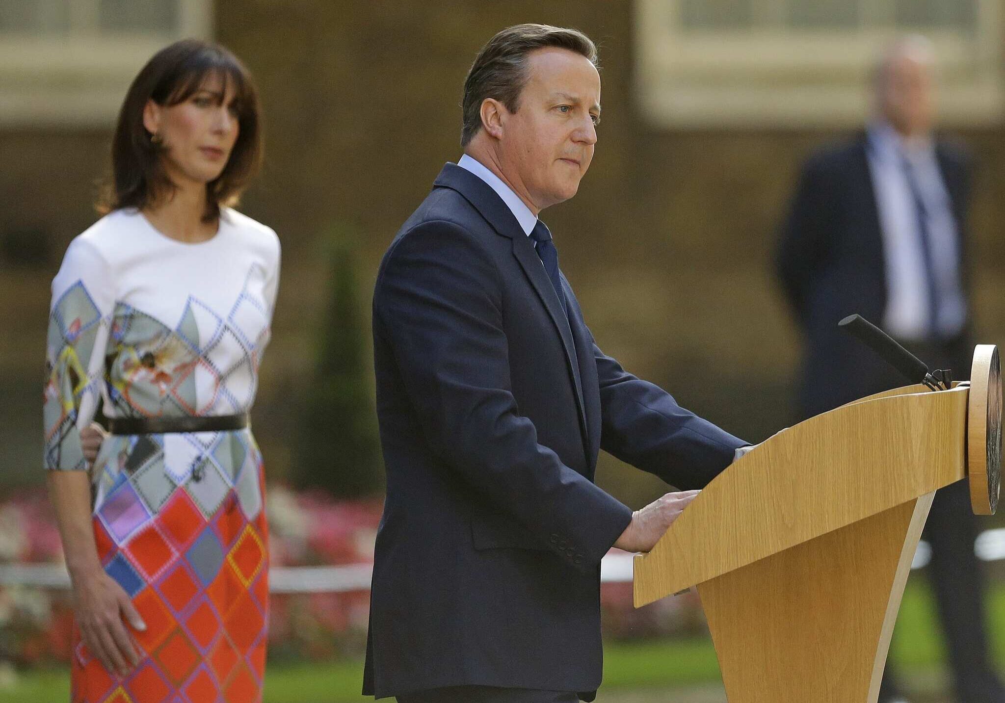 Britain's Prime Minister David Cameron speaks outside 10 Downing Street, London, as his wife Samantha looks on. Cameron says he will resign by the time of the Conservative Party conference in the fall.