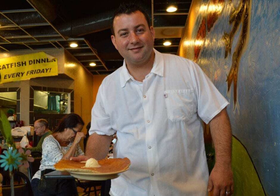 Nick de Feo, Jr.grabs a pancake during the morning breakfast rush. The pancakes are so big that if you took them for carry out, "we’ve got to put it in a pizza box," he says. (Photo: Jonathan Bender | The Recommended Daily)