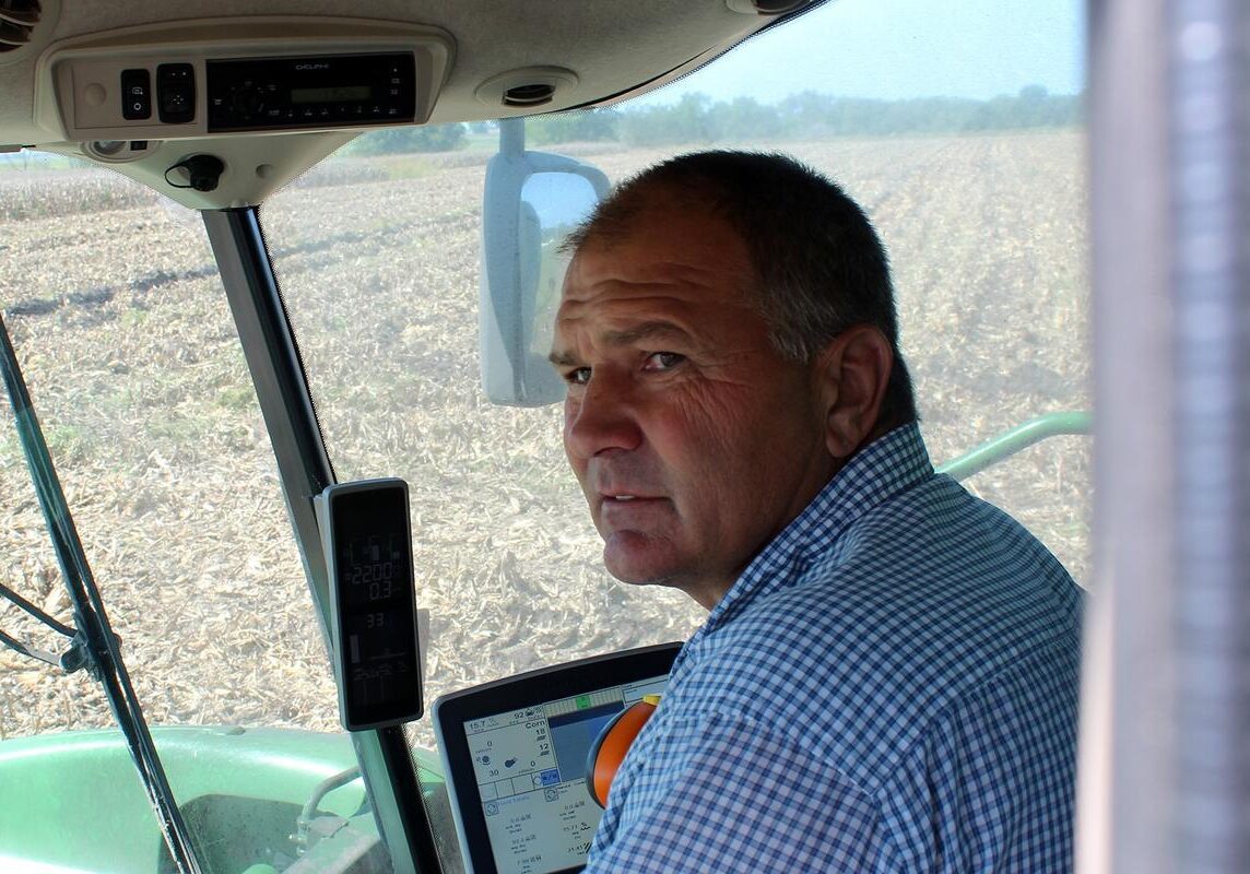 A man driving farm equipment through a field.