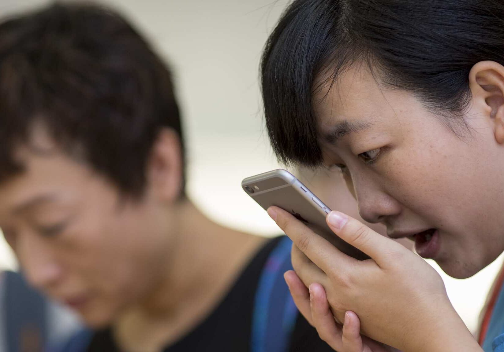 A customer tries the Siri voice recognition function on an Apple iPhone 6 Plus in Hong Kong.