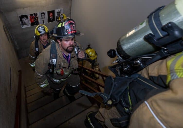 Robert Ohlsen from the Seneca, Kansas Fire Department, climbs another flight of stairs on Sept. 6, 2026, in honor of the 343 firefighters that lost their lives 25 years ago when the Twin Towers collapsed. The participating firefighters climbed 110 stories to represent the height of the Twin Towers. Posted on each landing are photos of firefighters killed in the aftermath of the terrorist attack. (Todd Feeback | Flatland)